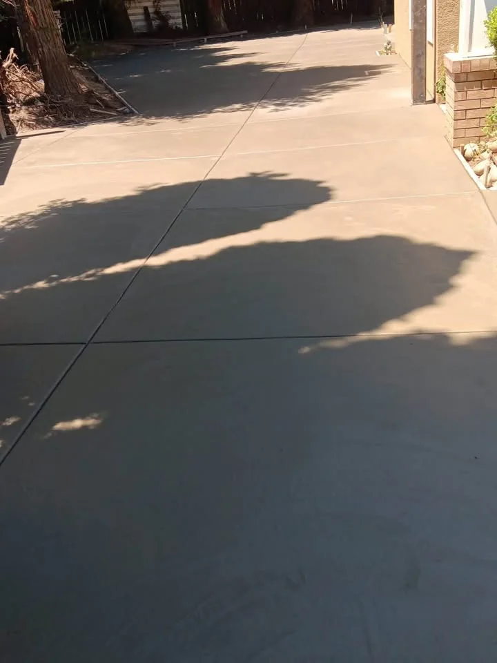 Close view of a finished concrete driveway in afternoon shade