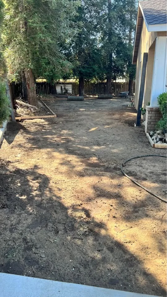 Prepared compacted base beside a home before a concrete pour