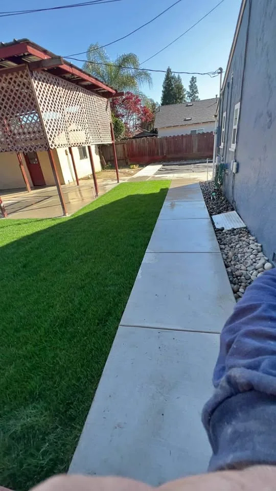 New concrete walkway beside freshly installed green sod