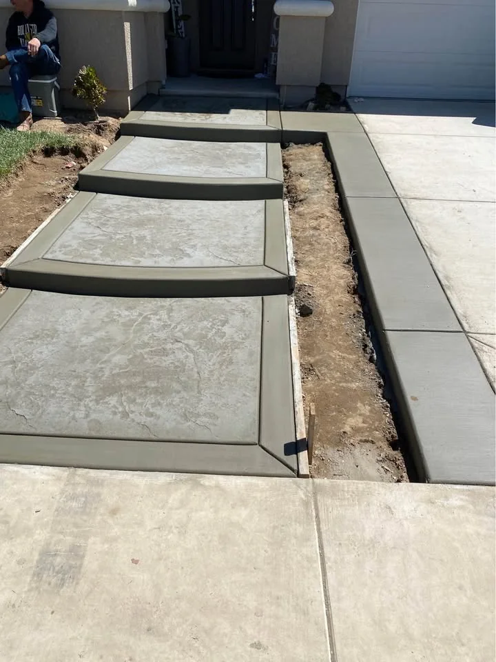 Newly poured concrete steps beside a driveway