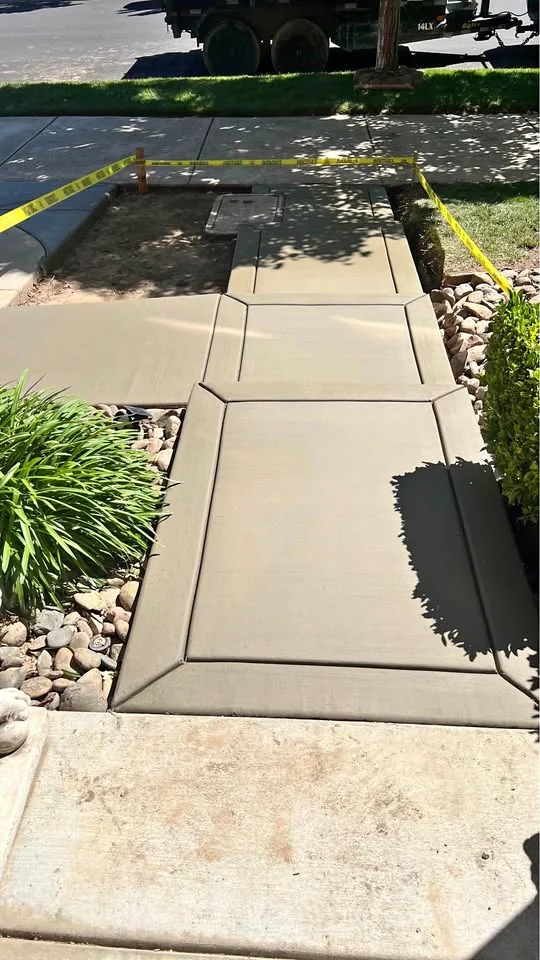 New concrete walkway and steps through a landscaped yard